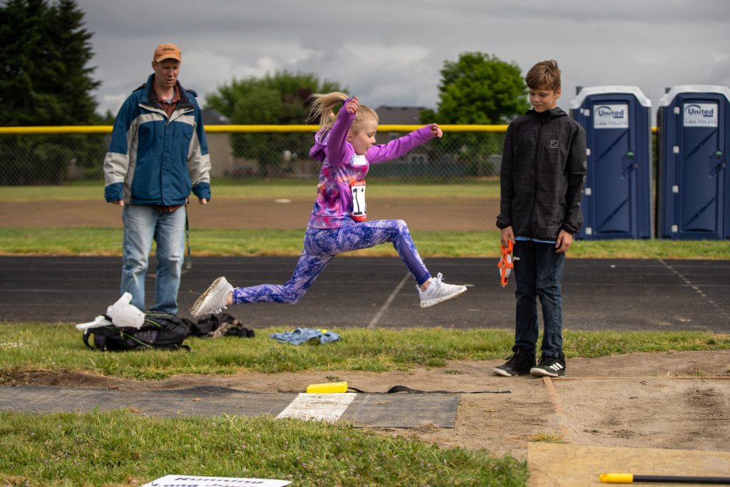 Girl jumping high and far in the long-jump for first prize