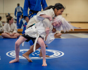Two young girls in a judo hold.