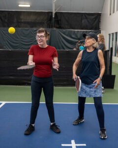 Athlete Olivia with her pickleball partner Sharon teaching her skills