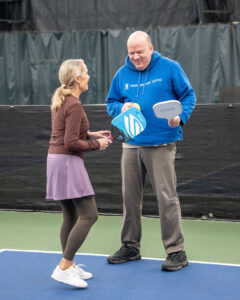Athlete Rick smiling with his pickleball partner and volunteer