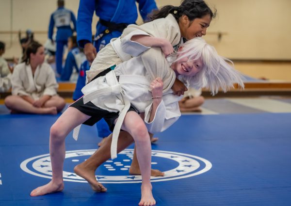 Two young girls in a judo hold.